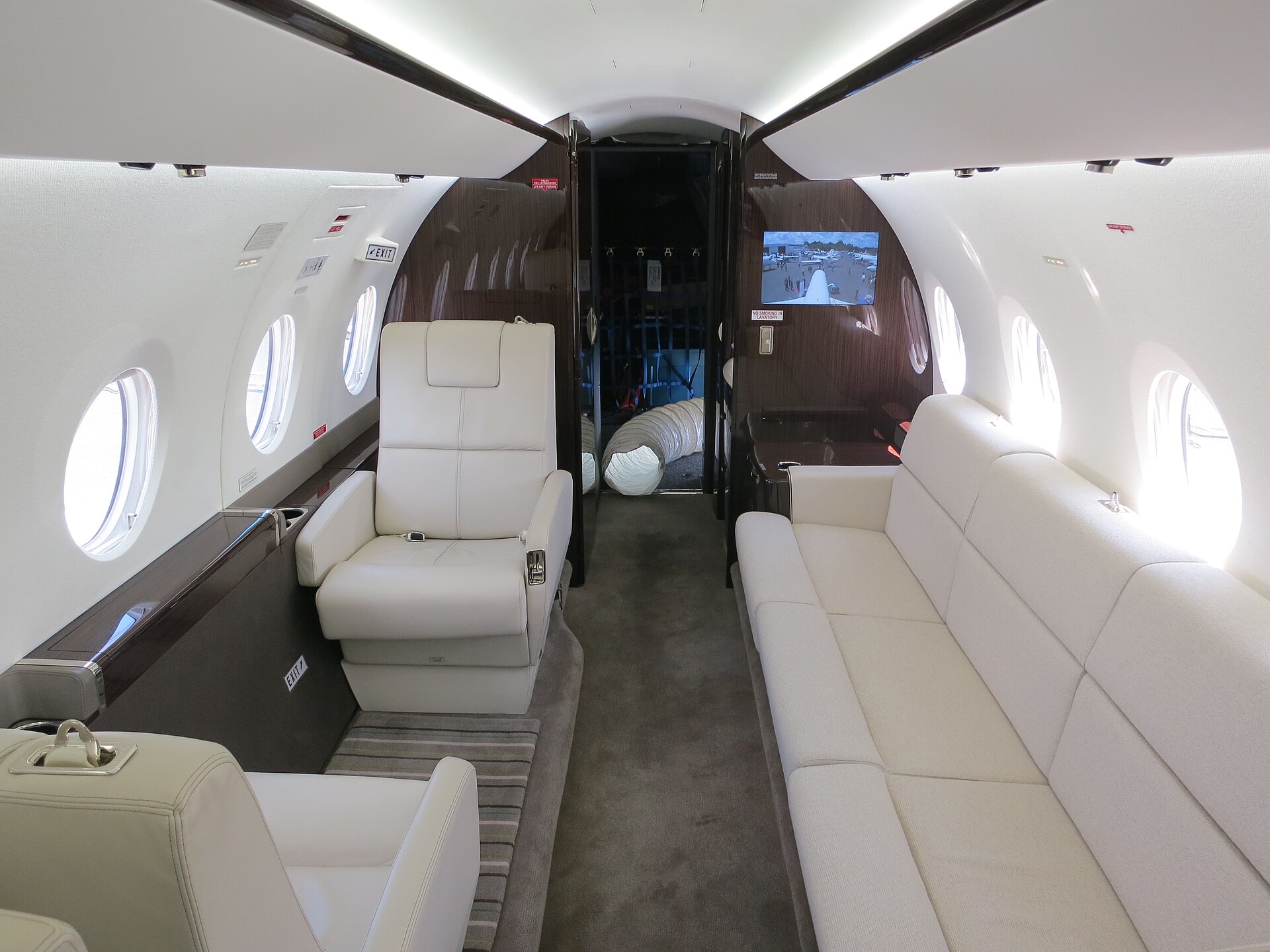 Business jet cabin interior with leather seats and a divan